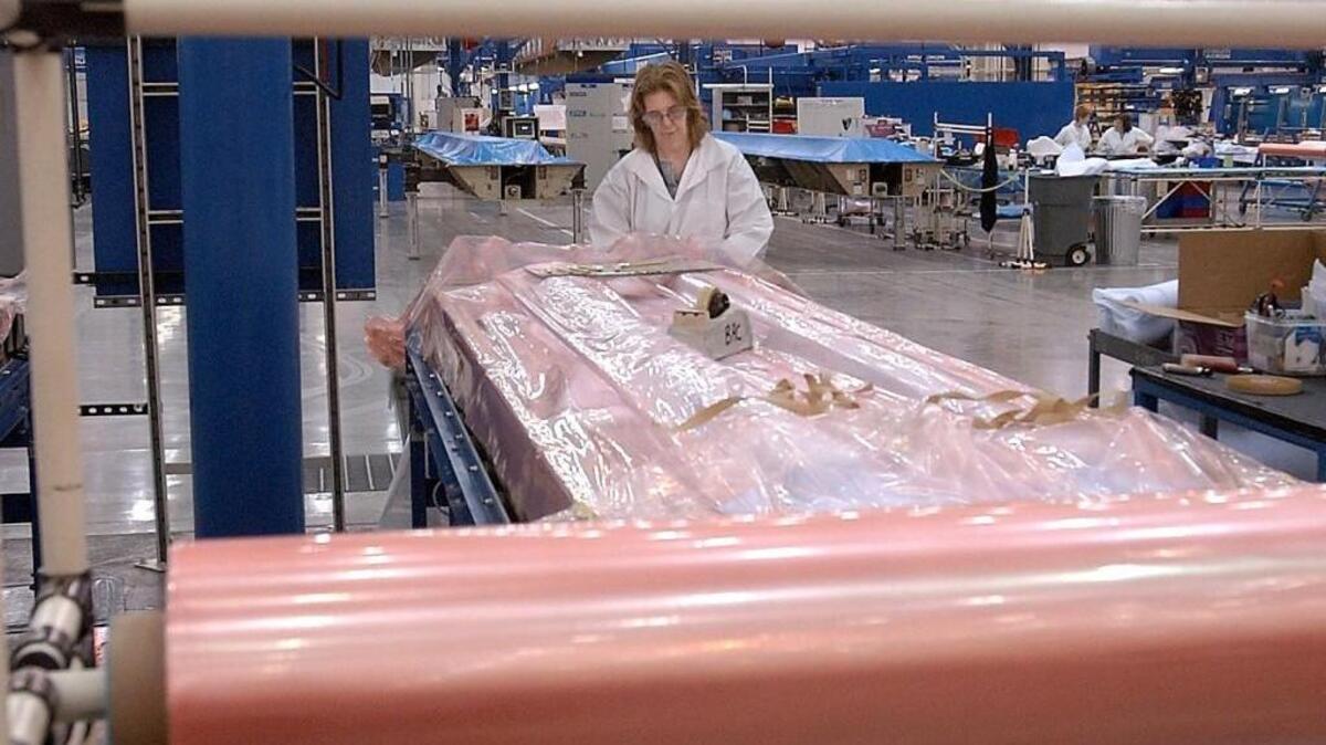 Debbie Box, a plastic bench mechanic, places nylon bagging material over composite angles before curing at the Boeing Frederickson Plant in Pierce County.