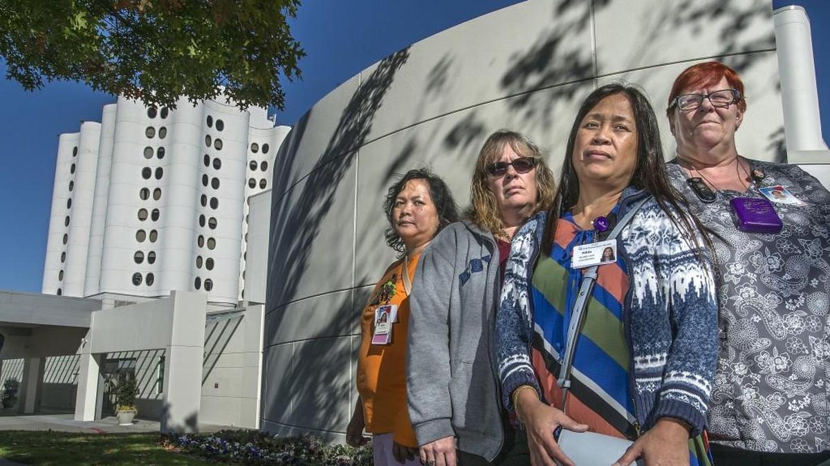 Health unit coordinators, from left, Ruth Hidalgo, Lori Weisinger, Nilda Warren and Tina Doyle, with close to 70 years of experience altogether, face layoffs from their jobs by Dec. 3 at St. Joseph Medical Center. Warren, a bargaining team member with SEIU 1199NW, said the hospital attributed the layoffs to the conversion to digital medical charting and cost-cutting measures. The workers say their jobs keep them busy.