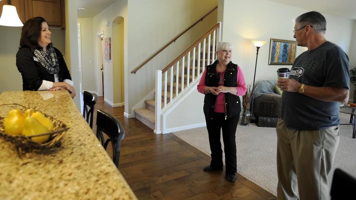 
Real Estate broker Francine Viola chats with prospective homebuyers Larry and Marcy Rosenlund at her Coldwell Banker open house Sunday in the Campus Highlands subdivision in Hawks Prairie. The Roselunds have their eye on another home, which is slated to be built soon.
