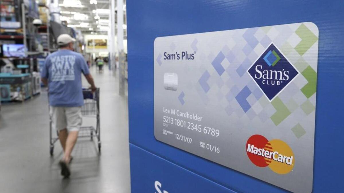 FILE - In this Thursday, June 4, 2015, file photo, a customer walks past a sign promoting the Sam's Club Mastercard credit card at a Sam's Club store store in Bentonville, Ark. Walmart is closing dozens of Sam’s Club stores across the nation. (AP Photo/Danny Johnston, File)