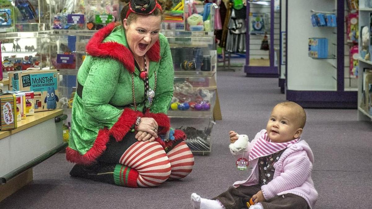 Nancy Chamberlain of Tacoma’s Learning Sprout Toys used her charm to occupy little RaVaye Stefani’s attention while her mom, Cynthia, shopped in November 2015. The store has announced that it is closing.