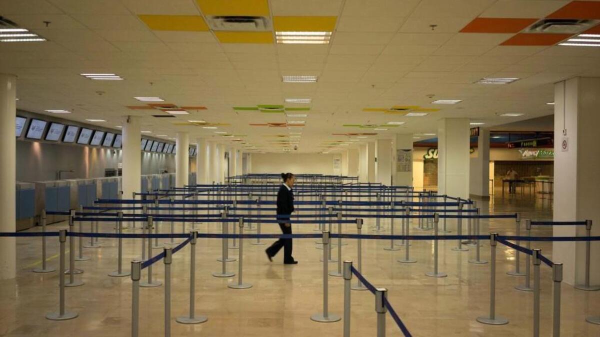 An airline employee walks in the empty airport in Puerta Vallarta, Mexico, where all flights are canceled as Hurricane Patricia approaches the Pacific resort city. Patricia headed toward southwestern Mexico Friday as a monster Category 5 storm, the strongest ever in the Western Hemisphere. Forecasters said could make a “potentially catastrophic landfall” later Friday.