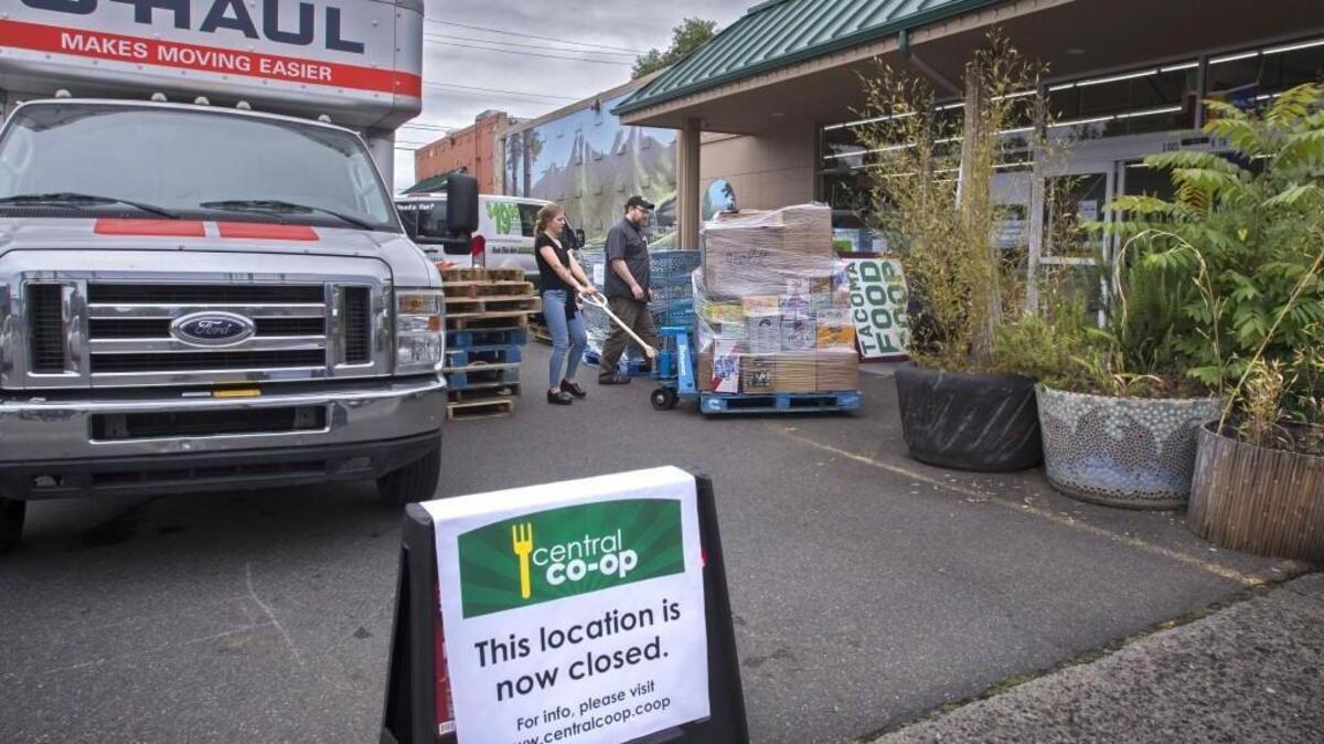 Central Co-op CEO Dan Arnett watches employee Shelby Alexander moves merchandise out to a moving truck at the closed Central Co-op in Tacoma July 18. The co-op says it remains committed to finding a new location for its Tacoma customers.