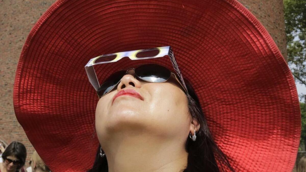 Ann Kim Tenhor, of Arlington, Mass., uses protective eclipse glasses to view a partial solar eclipse, Aug. 21 in Cambridge, Mass. Others were not so lucky to have the glasses, and doctors have seen patients fearing vision damage after the eclipse.