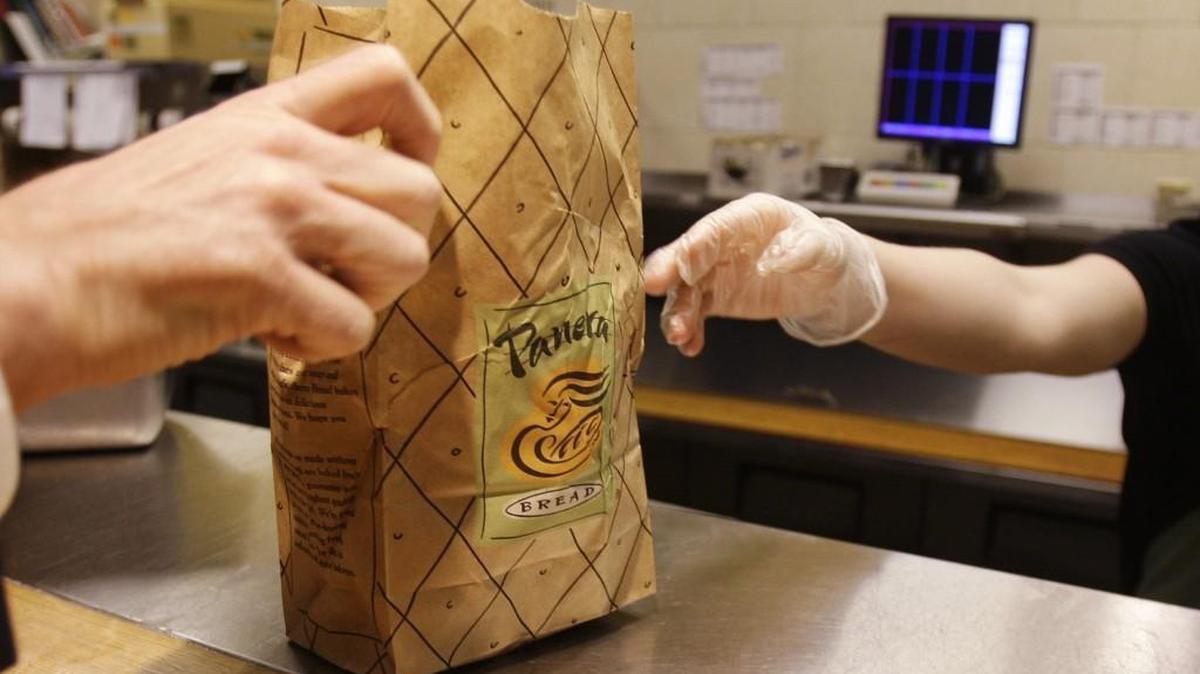 An employee passes an order to a customer at a Panera Bread store in Brookline, Mass. The chain is set to start hiring delivery drivers for the Seattle-Tacoma area.