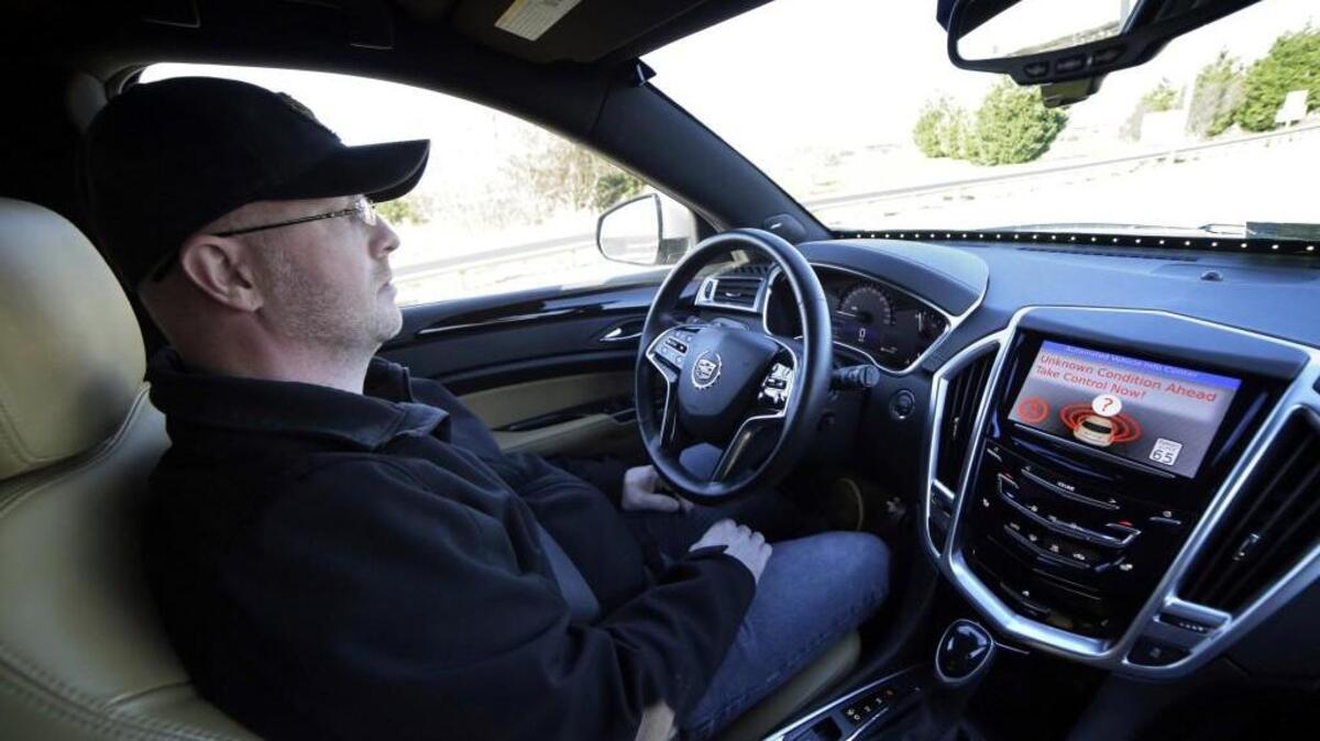 Virginia Tech Center for Technology Development Program Administration Specialist Greg Brown behind the wheel of a driverless car during a test ride showing the alert system handing over automation to the driver, while traveling street in Blacksburg, Va.