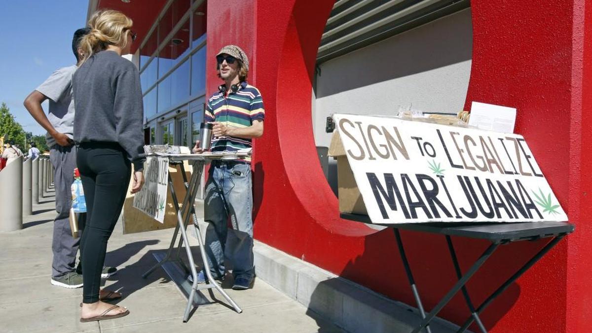 Petition signature gatherer Peter Keyes, right, discusses a petition to legalize marijuana April 23 in Sacramento, Calif. For the second time in six years, California voters are being asked to legalize the recreational use of marijuana.