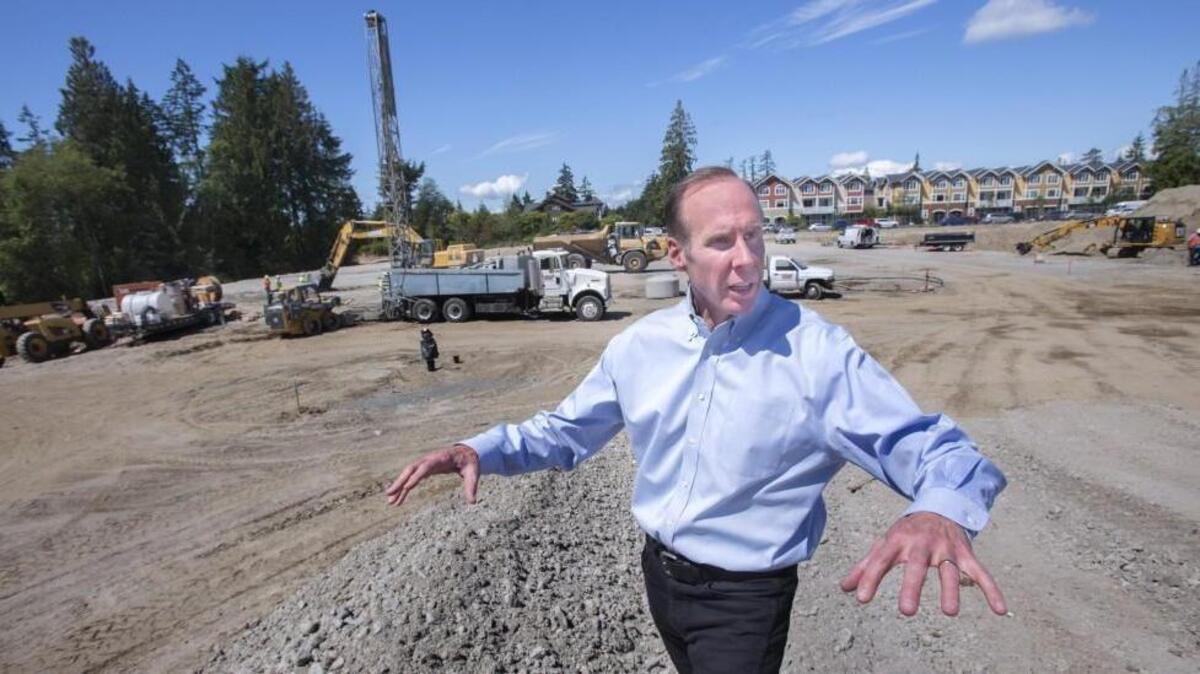 Former Starbucks COO Troy Alstead talks in July about his sustainable entertainment complex, with restaurant and bowling alley. It’s under construction at the Olympic Towne Center in Gig Harbor. Alstead described how the well drilling rig, in back, drills into the ground and will heat and cool his project.