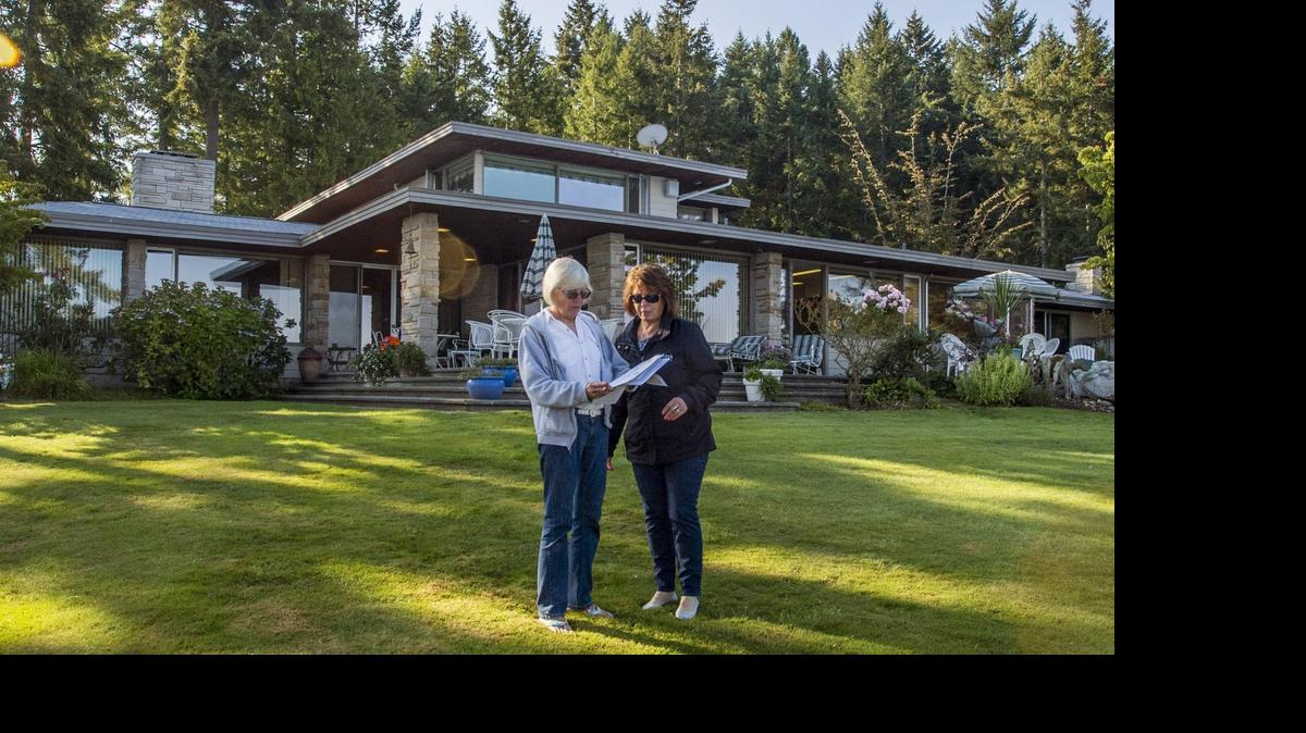 
Marion Chenaur (left) and realtor Marti Gardner in front of the large 1960's- era house with expansive views and easy beach access on the northern tip of Ketron Island that Chenaur is selling. August 26, 2014.
