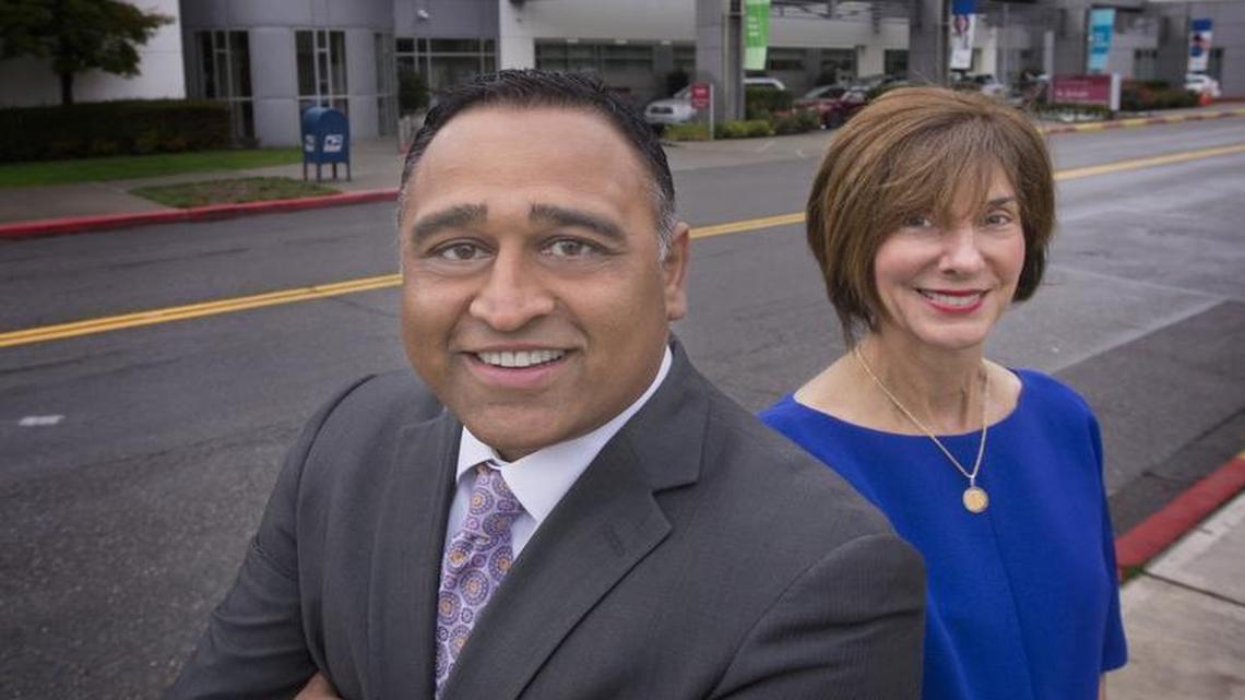 CHI Fransican Health CEO Ketul J. Patel and St. Joseph Medical Center President Syd Bersante in front of the system’s Tacoma hospital.