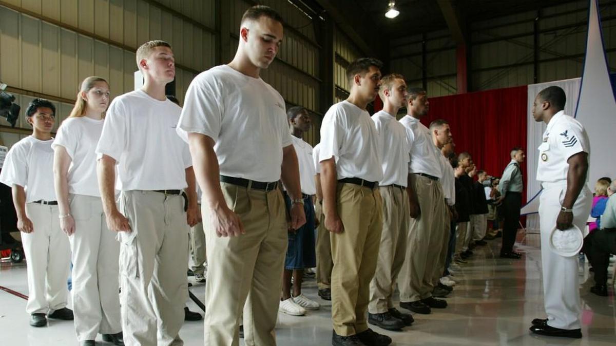 Naval service men and women get instruction from the recruiter in charge, W. Curtis Smith, right, after being sworn in to the Navy in Fort Lauderdale, Florida, in 2003.