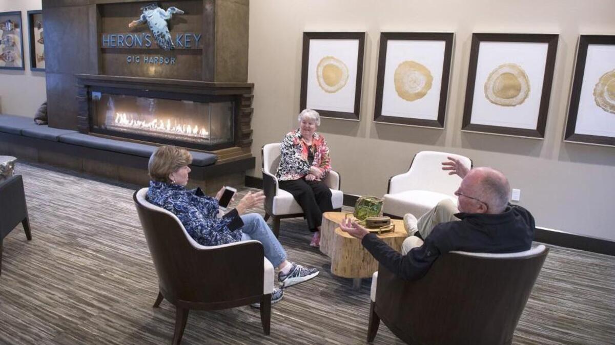 Gail Bierman (from left) talks with Sharon and Allan Hanson in the lobby at the Heron's Key retirement community in Gig Harbor in October. WSU in November announced a new online certification course for careers in senior living.