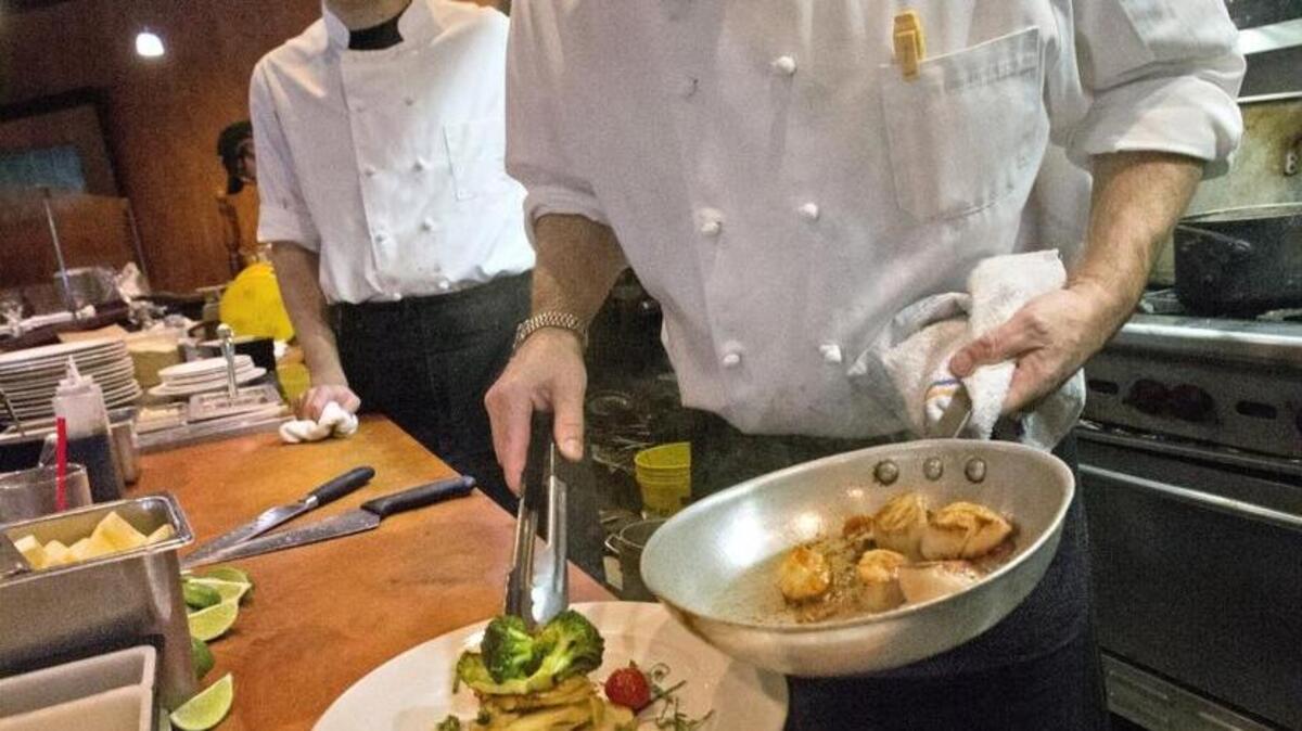 Charlie McManus, executive chef and co-owner of Primo Grill, prepares seared Alaskan sea scallops, potato gratin, broccoli, citrus tarragon beurre blanc. In the foreground is steamed Kamilche Farms mussels (from near Shelton), chive curry cream. Primo Grill is among 11 restaurants in Pierce County donating a portion of proceeds to help refugees and immigrants at Tacoma Community House.