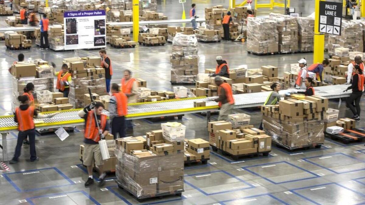 Workers fill orders and prepare packages for mailing at the Amazon fulfillment center in Kent on Nov. 17, 2014. Amazon is hiring thousands of workers to handle the holiday rush in 2015.