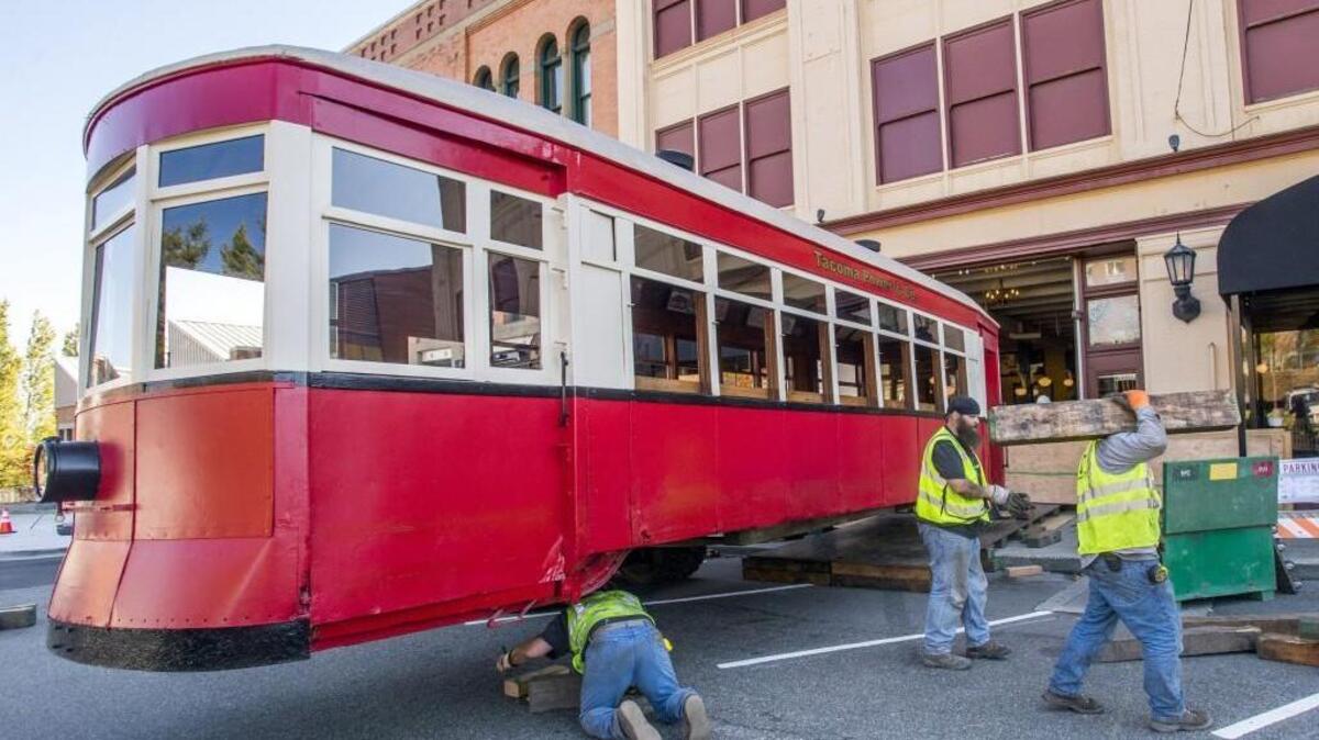 
Workers remove blocks as the trolley is held up by a forklift outside The Old Spaghetti Factory in Tacoma on Saturday. 
