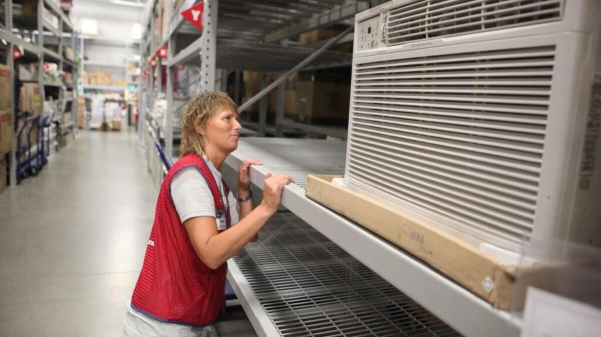 Tammy Messer, a sales associate in the seasonal department, checks information on the last remaining air conditioner at Lowe’s in Olympia in the summer of 2009. Installing air conditioning was just behind home painting and installing a concrete patio as the most popular home improvement for area millennials, according to a new survey.