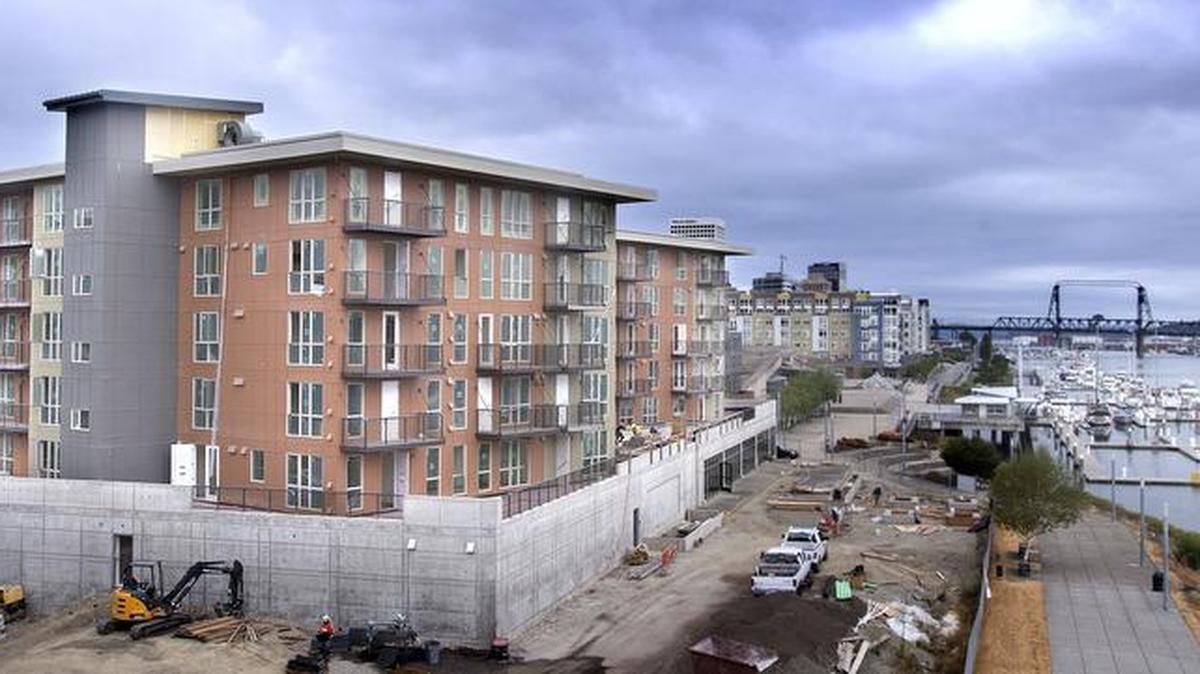 
Construction workers are shown Tuesday working on The Henry waterfront apartments, a $32 million building that broke ground last year on the north side of the state Route 509’s cable suspension bridge. 
