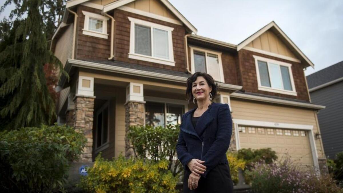 Real estate broker Regina Madiera-Gorden stands outside a house for sale in University Place on Nov. 2.