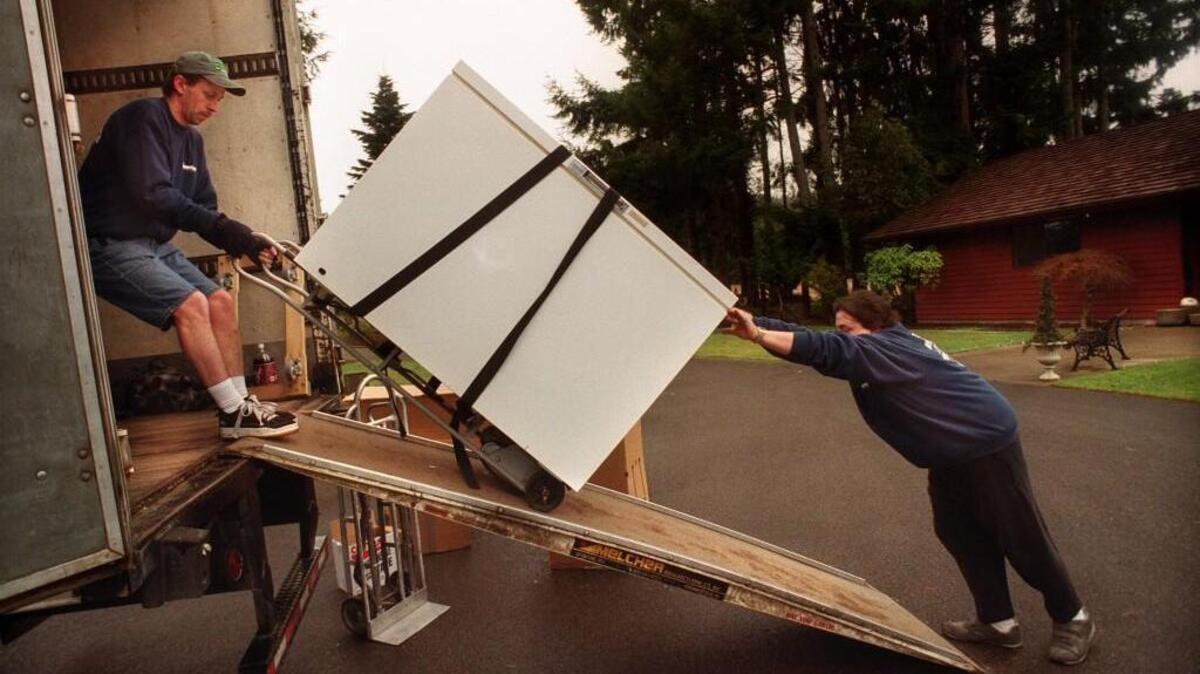 Mike Wheeler, left, and Chuck Onzinian of Olympic Movers loaded a freezer onto their van for Jerry Oson, who moved to Hood Canal from his Thurston County home in 2000.