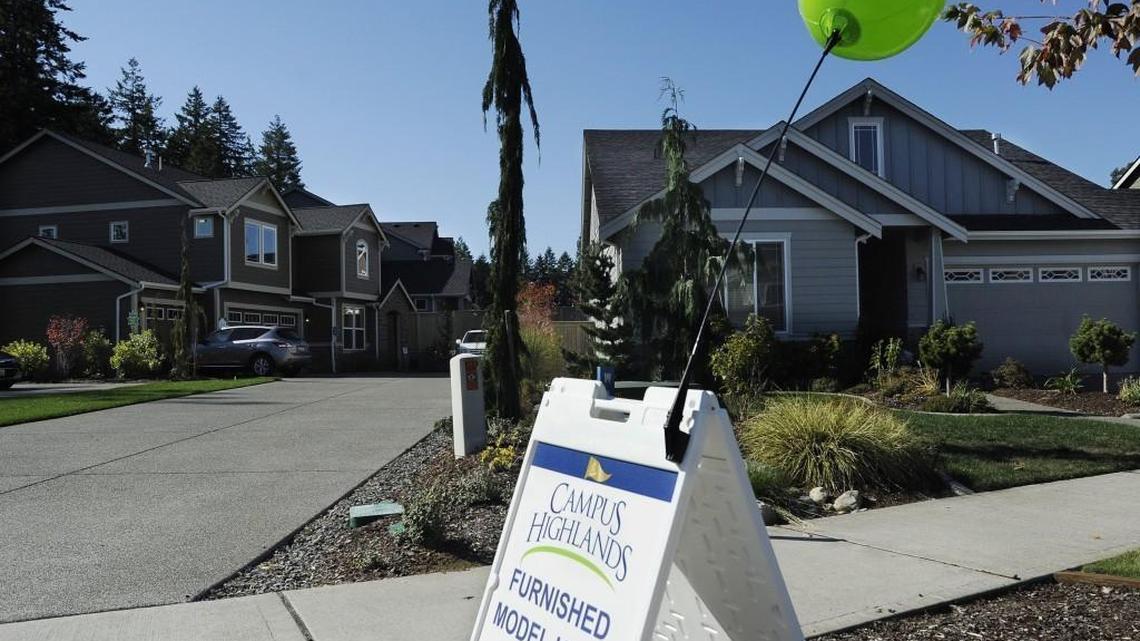 Real estate broker Francine Viola holds an open house in a Hawk Prairie subdivision in Campus Highlands in 2015. New data show wages not keeping pace with rising home prices.