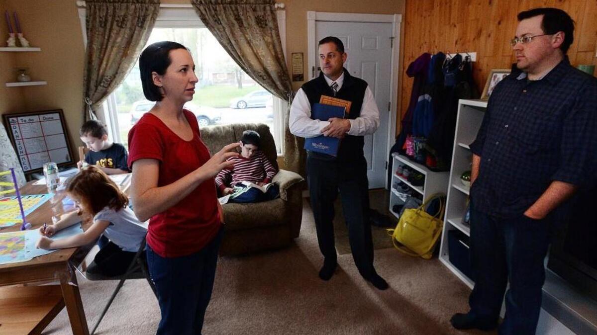 
In a living room that doubles as a classroom for their homeschooled children, Michelle and David Allen shared concerns in 2014 with Windermere realtor Stephen Janho, second from right. The couple bought their home at the real estate market’s peak in 2007. In 2014 they had outgrew it, but were unable to move because their mortgage is underwater. Last week, Michelle Allen said the family had an offer above asking price.
