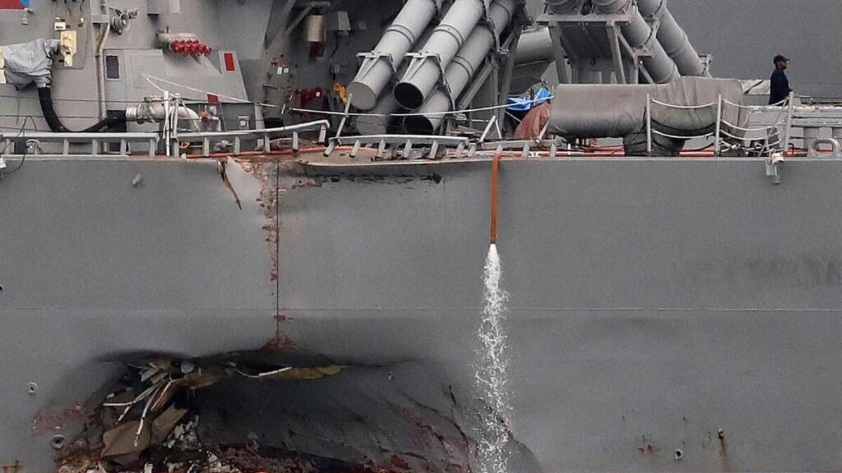 The damaged port aft hull of the USS John S. McCain, is visible while docked at Singapore’s Changi naval base last month. Military leaders say military readiness has taken a hit from budget fights in Congress and that high-profile accidents like ship collisions and other routine training mishaps are a direct result.