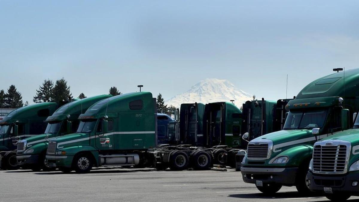 Mount Rainier peaks over rows of trucks at Interstate Distributor Co. in 2011. Interstate is being acquired by Heartland Express in a $113 million deal.