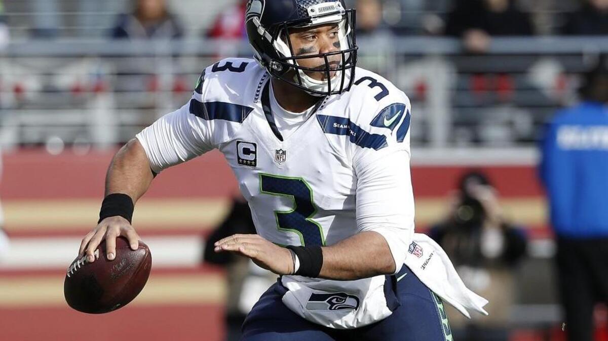 Seahawks quarterback Russell Wilson drops back to pass Jan. 1 in a game against the San Francisco 49ers in Santa Clara, Calif. Any Alaska Airlines passenger wearing Wilson’s jersey will get priority boarding at Seattle-Tacoma International Airport through the end of the year, the SeaTac-based airline announced Friday.