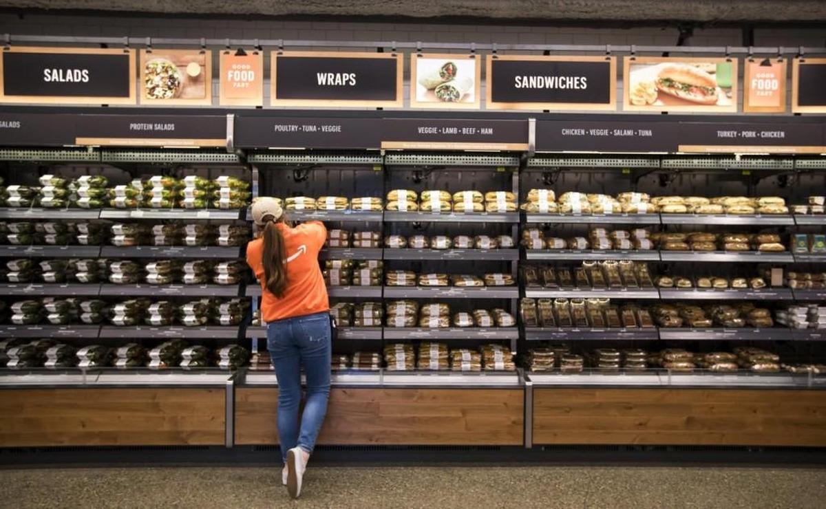 An employee restocks shelves recently at the Amazon Go store