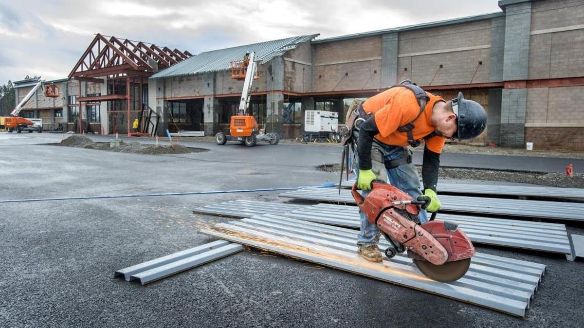 A construction worker cuts steel decking Thursday for the roof of the new Fred Meyer grocery store in Gig Harbor. The store is scheduled to open in late May.