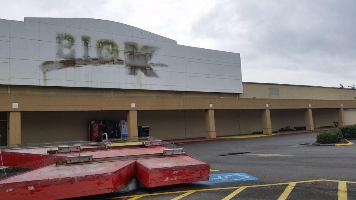 Tacoma’s former Kmart on Sixth Avenue, with the signage in a scrap heap on the site’s parking lot in March.