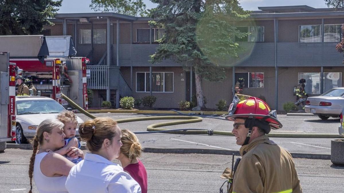 West Pierce Fire & Rescue Capt. Art Rausch talks to a manager of Legacy Park Apartments in Lakewood on Tuesday afternoon. He was helping to find assistance for the residents of several apartments damaged by a fire.