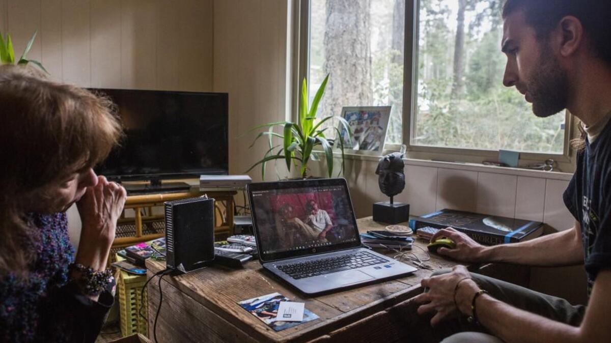 Paula, left, and Jordan Somers look through photos of Luke Somers at Paula’s home. Paula and Jordan Somers are putting together an exhibition of Luke’s photography that will be on display at Seattle University.