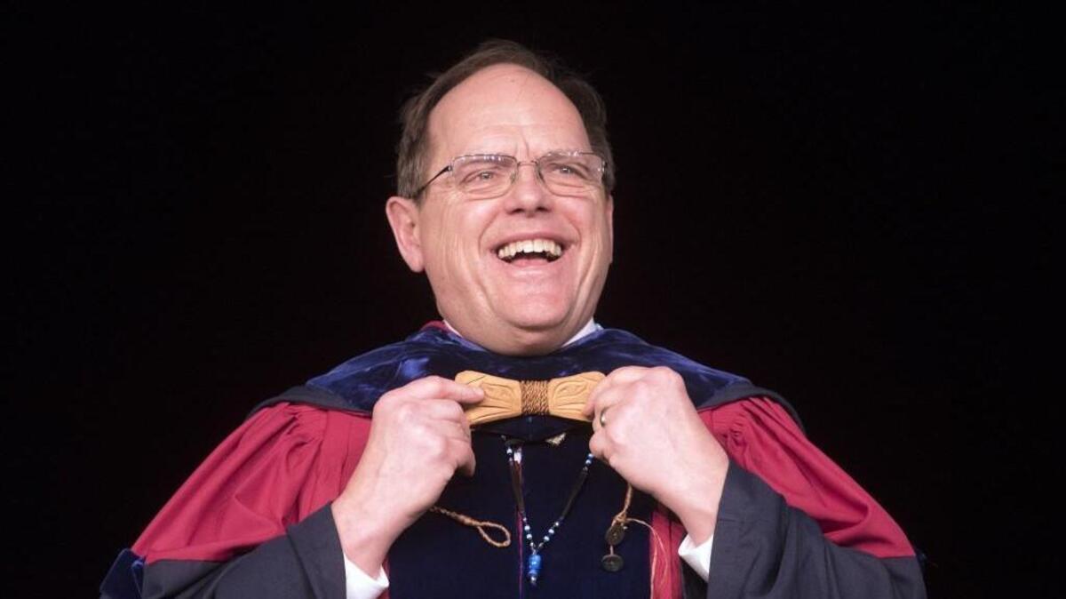 New college president George Bridges shows off the handmade wooden bow tie given to him Friday by Skokomish master carver John Edward Smith during his inauguration celebration at The Evergreen State College in Olympia.