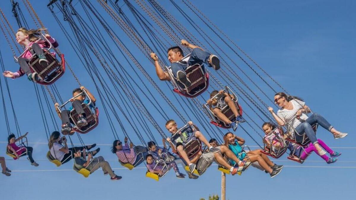 Washington State Fair patrons riding the Wave Swinger at the fair in Puyallup last fall. The fair will be hiring this week.