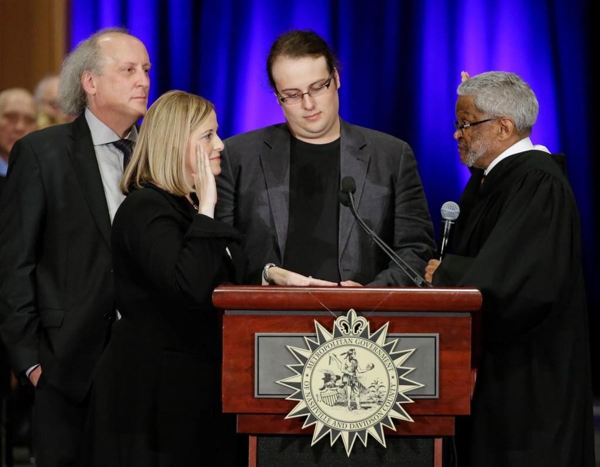 Nashville Mayor Megan Barry, second from left, is sworn into office by Judge Richard Dinkins, right, with her husband, Bruce, left, and son, Max, second from right, in Nashville, Tenn. A statement released Sunday, July 30, 2017, from Megan and Bruce Barry, said their only child, Max Barry, died Saturday night in Denver from an apparent drug overdose.