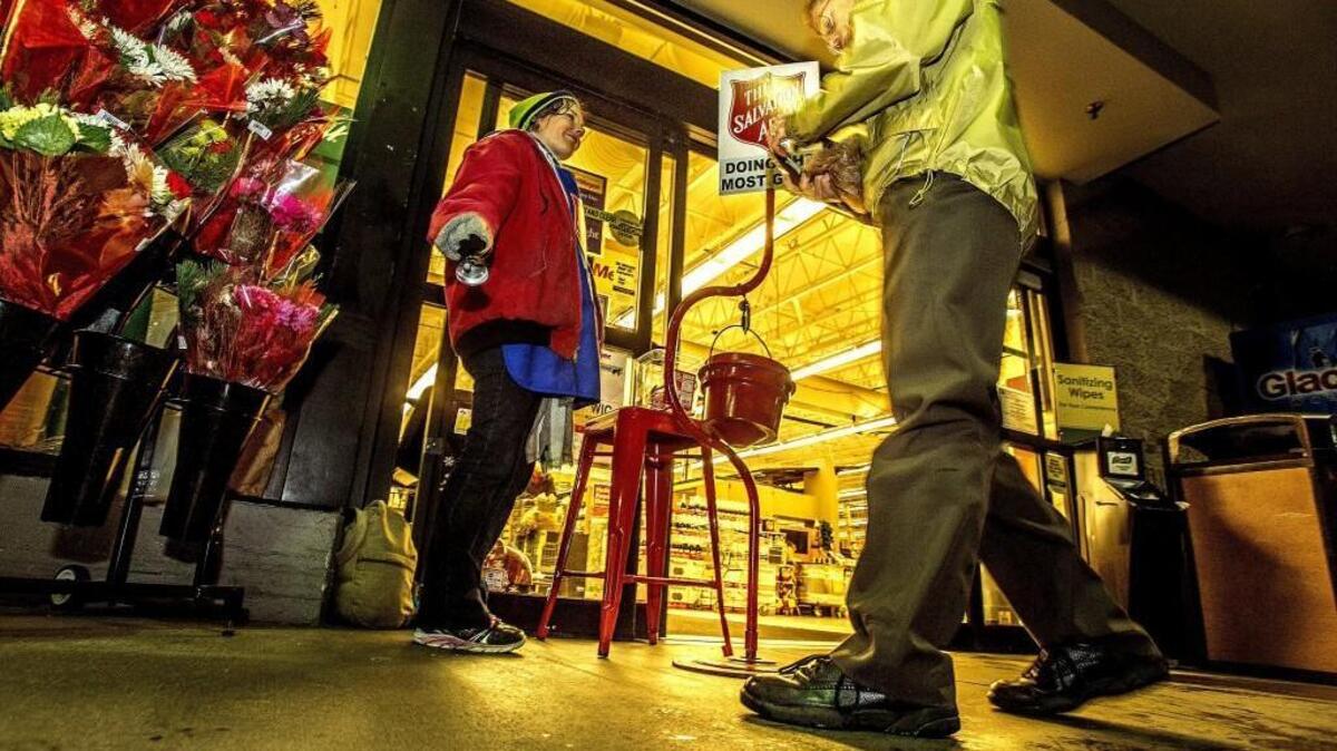 Audrey Frick, of Tacoma, rings her bell outside the Fred Meyer grocery store in Gig Harbor on a rainy and cold Monday night, Dec. 21, 2015. Donations to the Salvation Army’s red kettles, which sit outside stores during the holiday season, are down 15 percent in Pierce County this year.