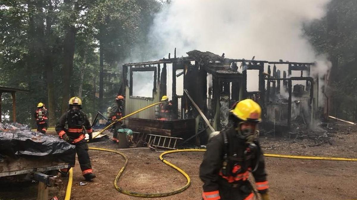 Key Peninsula firefighters extinguish what’s left of a house fire Saturday morning on Herron Island. The home was a total loss, Chief Guy Allen said.