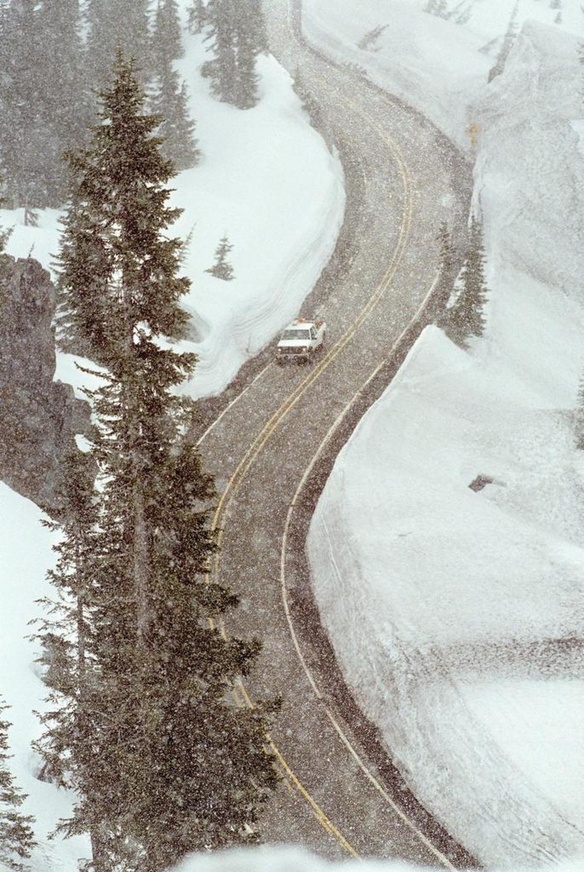 In this file photo from 2011, a Washington Department of Transportation vehicle heads down to the west gate of Chinook Pass on State Route 410 to open it for the season Thursday, May 15, 2003.
