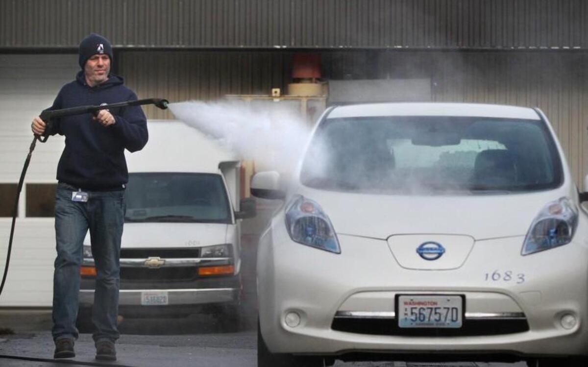 Paul Hanna, fleet and facilities supervisor for the City of Olympia, washes off a Nissan Leaf all-electric car in 2013. The state recently announced plans to spend $1 million to build charging stations along some of Washington’s busiest highways.