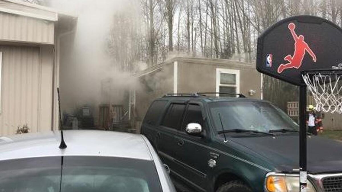 Smoke billows from a Kent mobile home Tuesday after unattended cooking started a kitchen fire. Firefighters rescued two dogs from the burning home.
