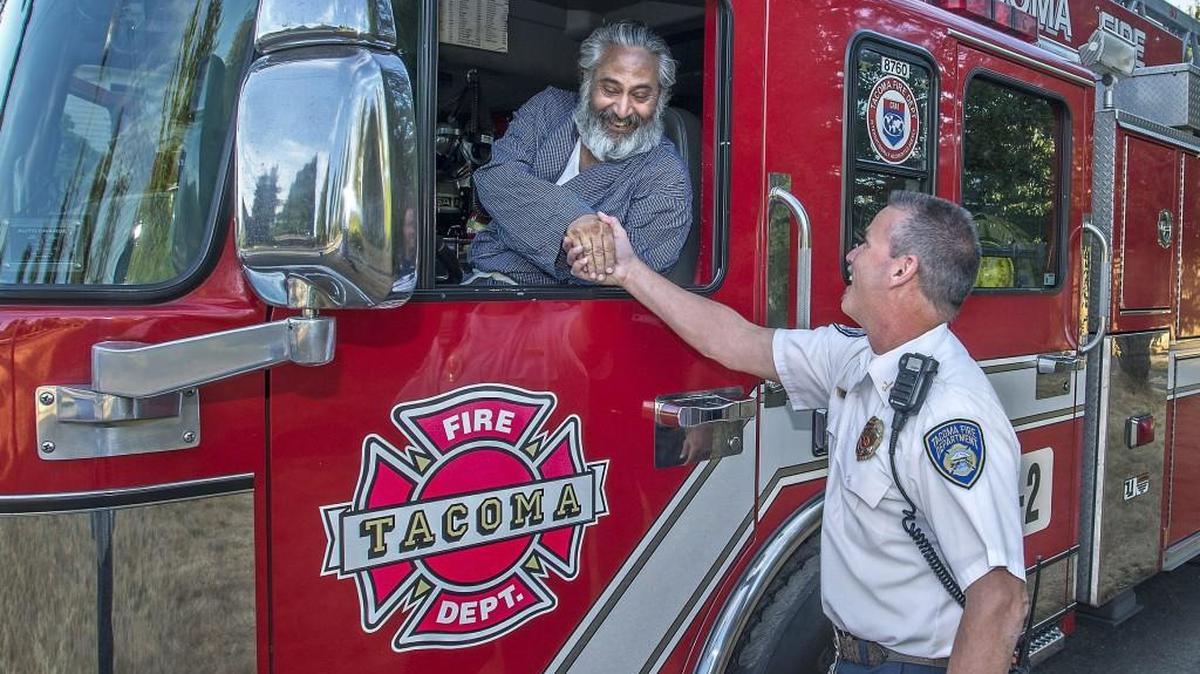 Mike Malik, left, got to fulfill a dream in sitting in a ladder truck during last year’s National Night Out celebration hosted by Lincoln Area Watch Group in Tacoma. At right is Battalion Chief Ray Manglona.
