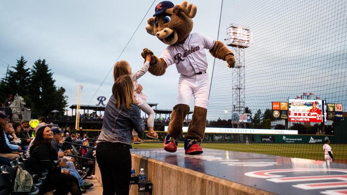 Rhubarb gives a high-five to a young fan as he dances on the dugout during the Tacoma Rainiers’ game against the Las Vegas 51s at Cheney Stadium in Tacoma, Wash., on Thursday, June 28, 2018.