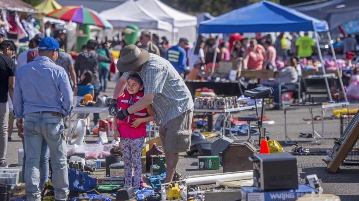 Lucero Dejesos-Cruz gets fitted with a new life vest at the Star Lite Swap Meet in Lakewood on Sunday.