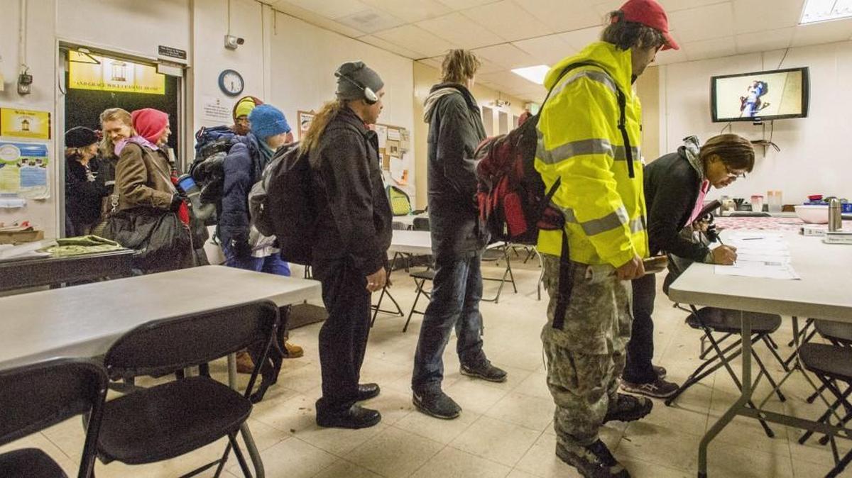 A couple of dozen homeless people enter and register in New Hope Resource Center in downtown Puyallup when it opens at 5:30 p.m. as part of its Freezing Night Program, December 23, 2016. At 7 p.m. they will be taken to churches which have sleeping space for the night.