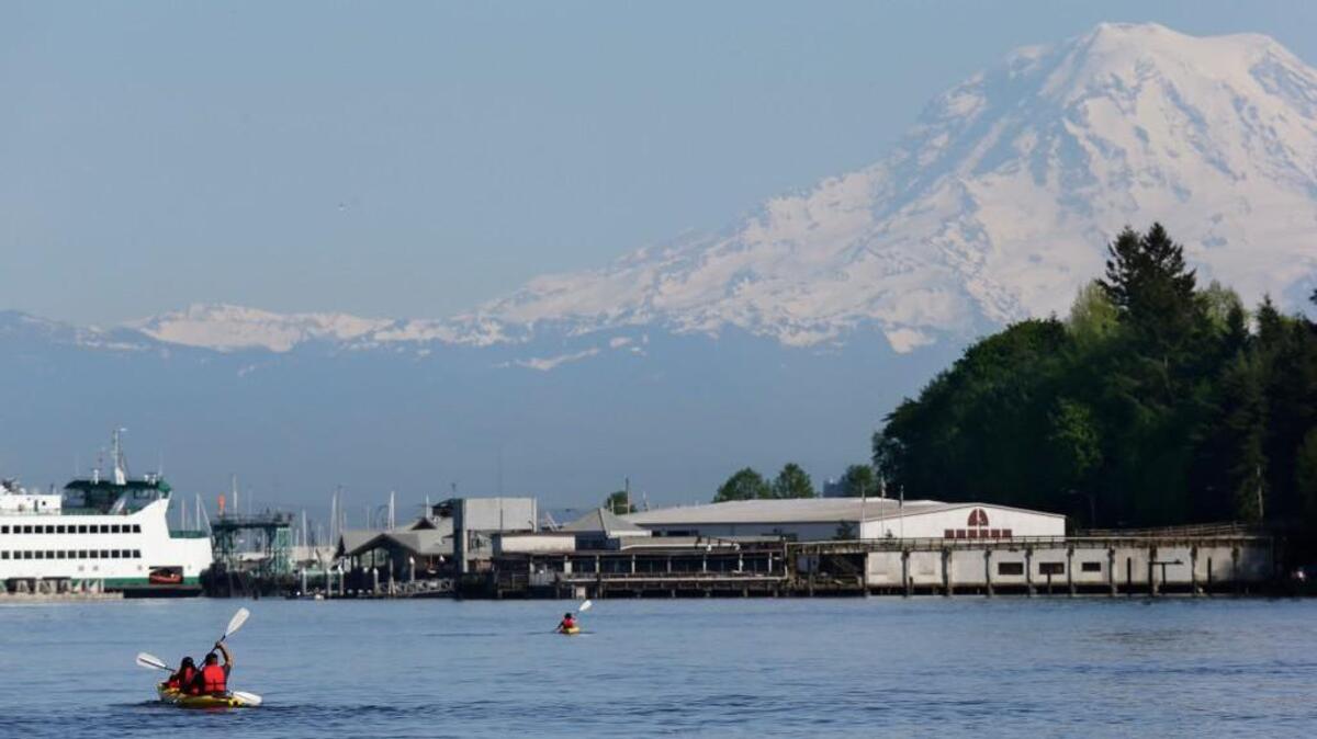 With Mount Rainier in the background, kayakers paddle near Owen Beach in Point Defiance Park on Monday in Tacoma. Temperatures were at record levels in Western Washington Monday.