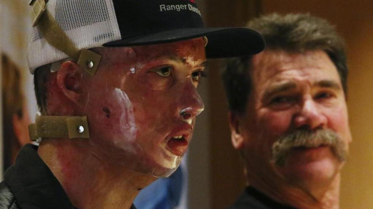 Daniel Lyon, Jr., the firefighter who survived the deadly Twisp blaze, speaks during a news conference at Harborview Medical Center, Wed., Nov. 18, 2015, in Seattle. At right is his father, Daniel Sr.