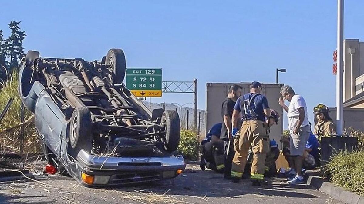 Tacoma Fire helps an occupant of a vehicle that tumbled off of southbound Interstate 5 south of the S. 5th street interchange, July 29, 2017.