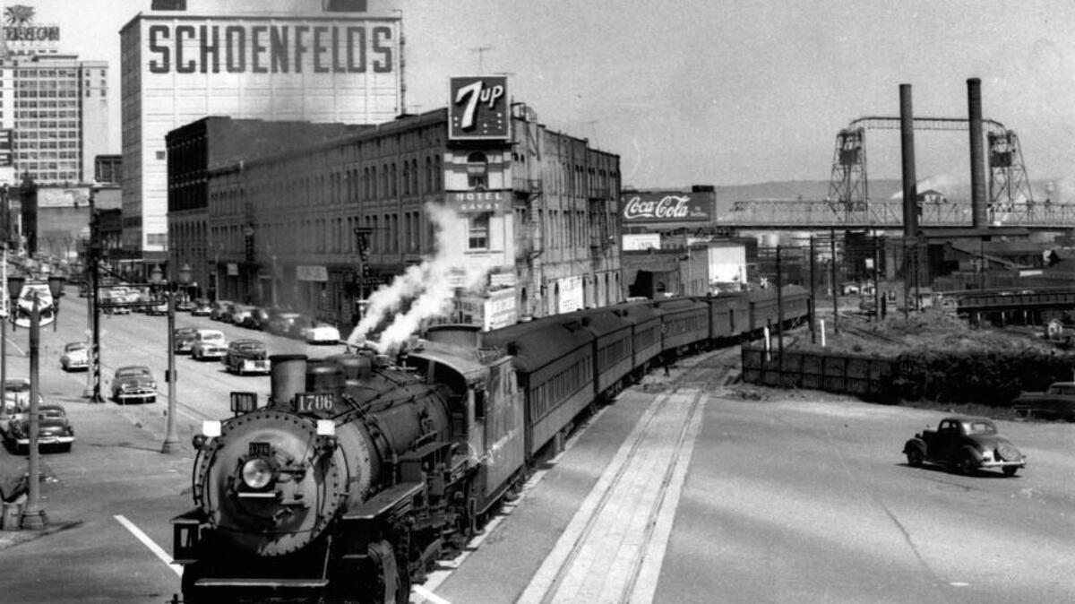 Tacoma railroad historian Jim Fredrickson took this photo of an Army troop train heading to Fort Lewis in 1951. The train crosses Pacific Avenue at Hood Street, with the Croft Hotel, also known as the Savoy Hotel, in the background. The site became home to the Tacoma Art Museum.