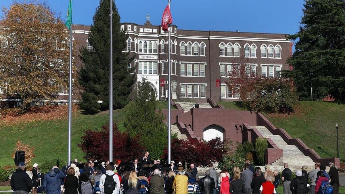 Students a faculty hold a ceremony in 2014 at Saint Martin’s flag pavilion. Nontenured faculty at the private university voted in June to form a union, and the administration is fighting that effort. Faculty are planning to participate in a walkout scheduled for 1 p.m. Tuesday (Nov. 29) over the matter.